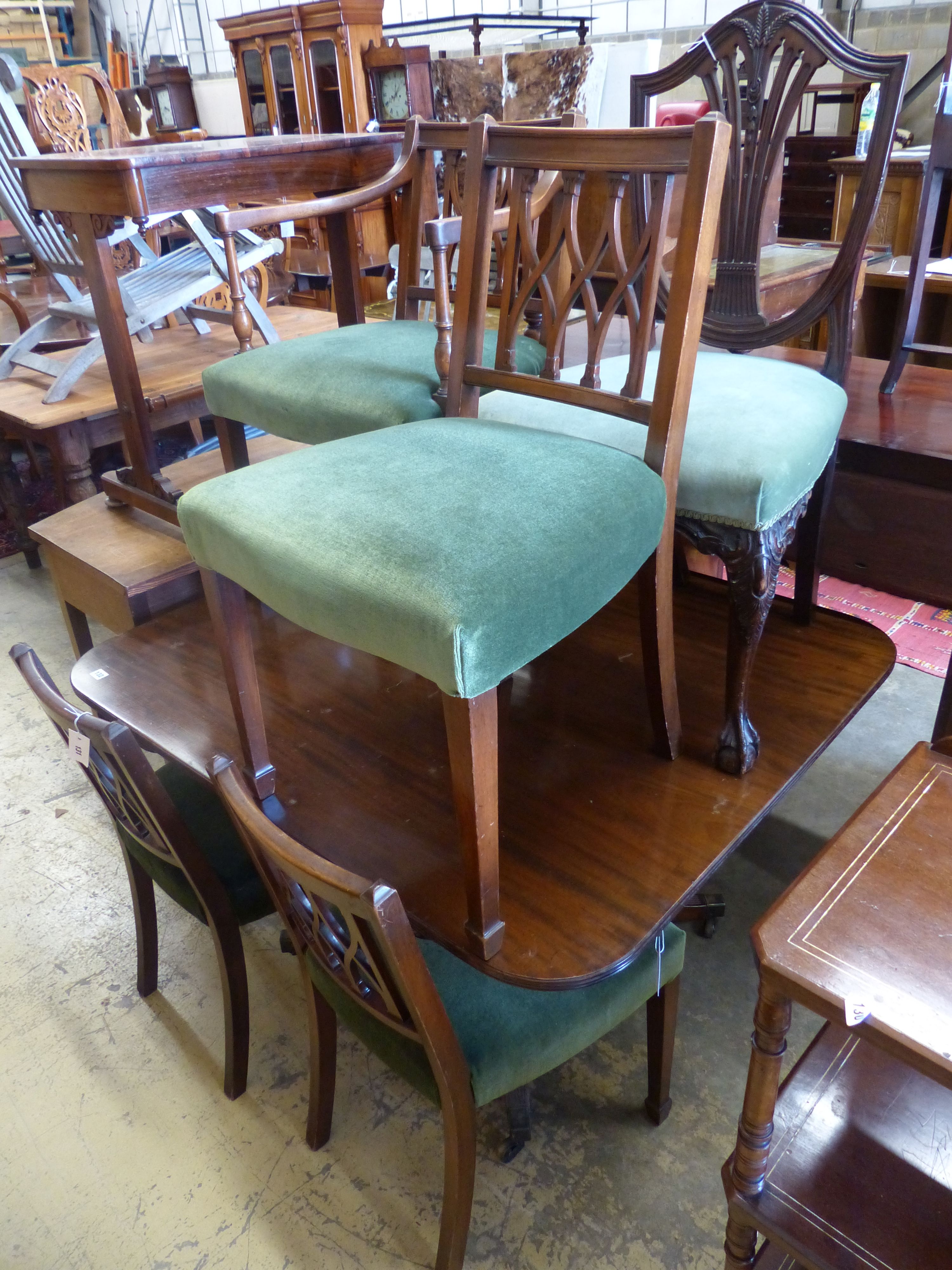 A set of four Sheraton style mahogany dining chairs, one with arms together with a Hepplewhite style dining chair